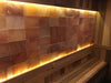 Pink Himalayan salt wall panels installed with warm backlighting above a sauna bench